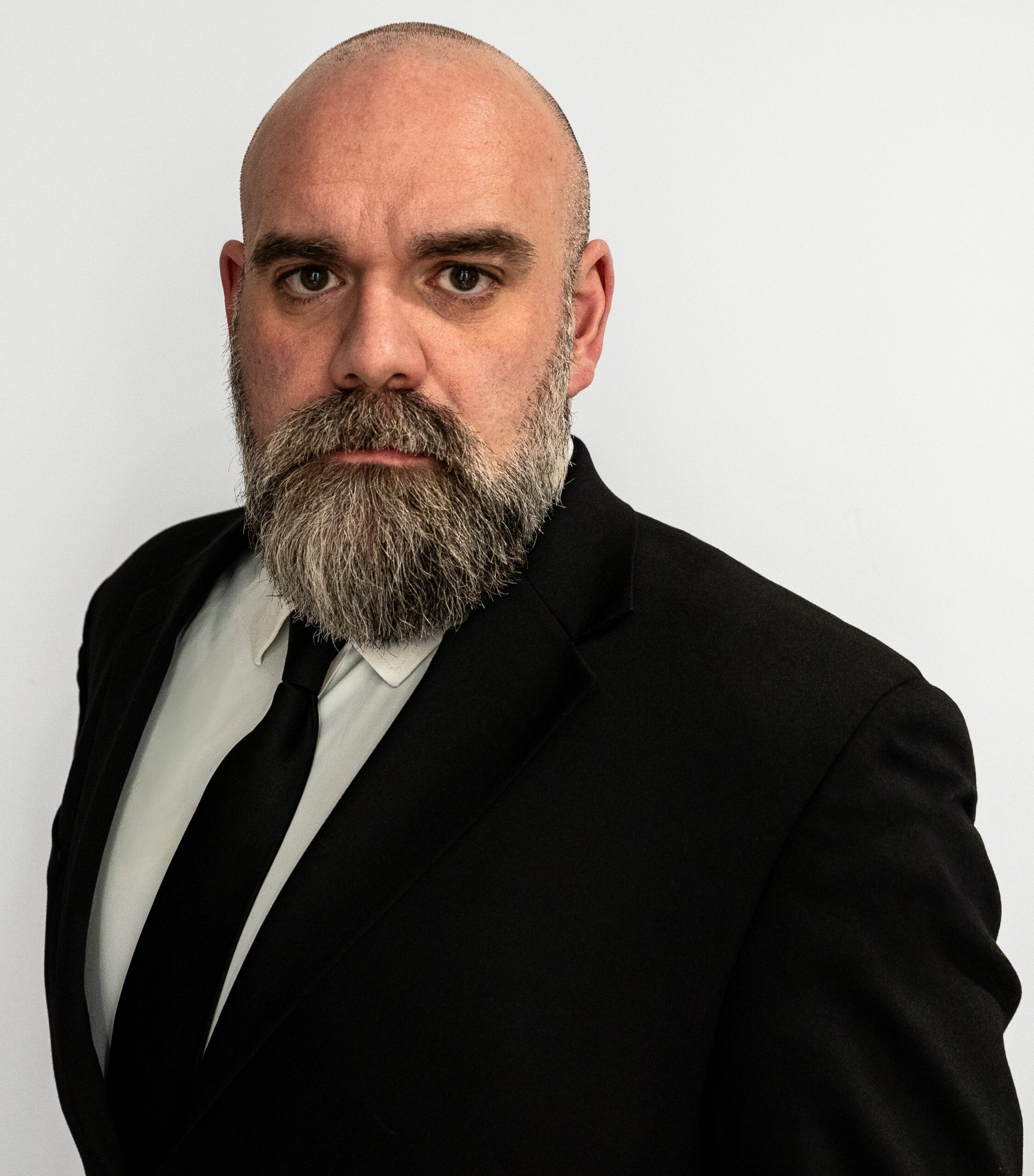 Portrait of instructor T.J. Young in a dark suit against a light background